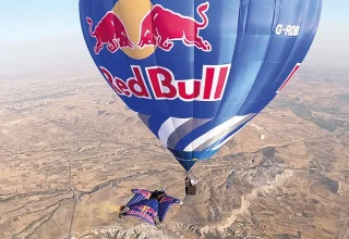 Wingsuit-atleten vliegen tussen heteluchtballonnen boven Cappadocië
